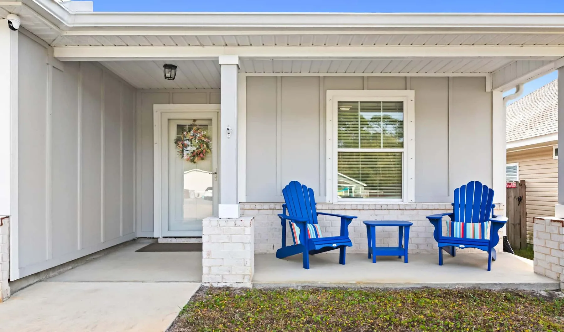 A covered porch with blue seating and a small table.