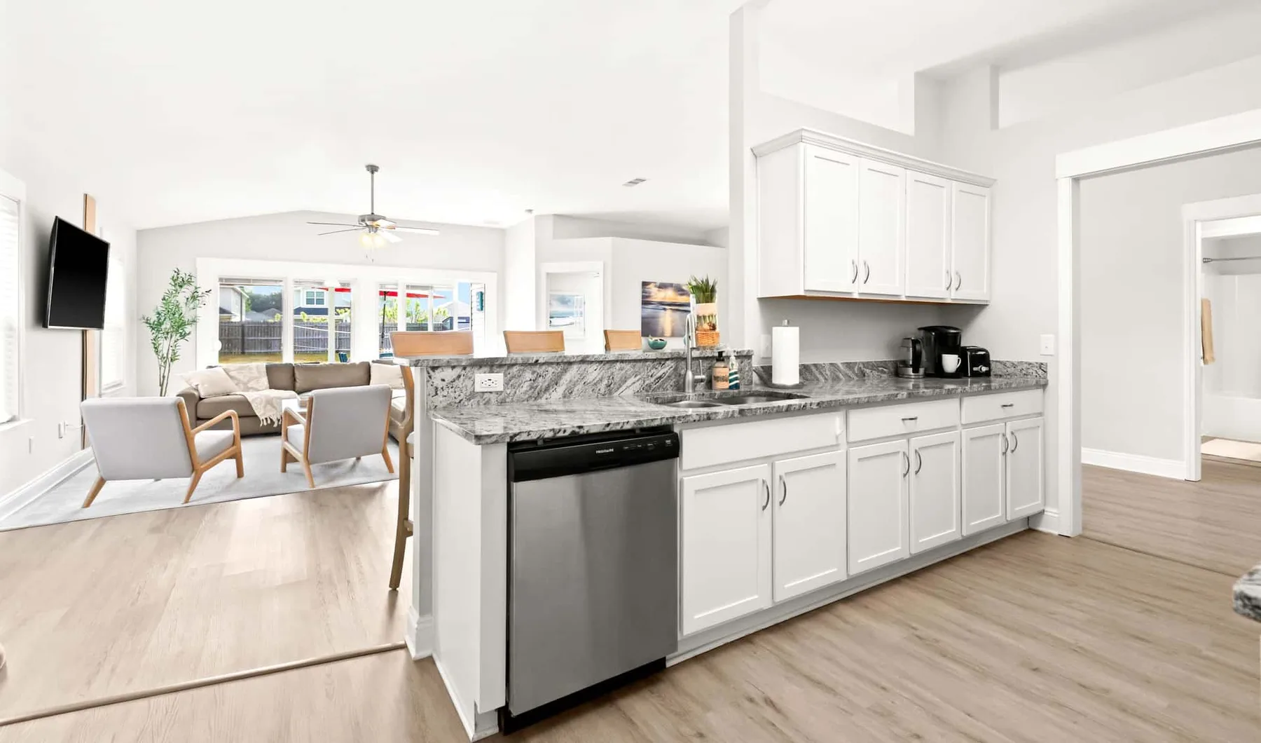 An open-plan kitchen and dining area with white cabinets and a central island.