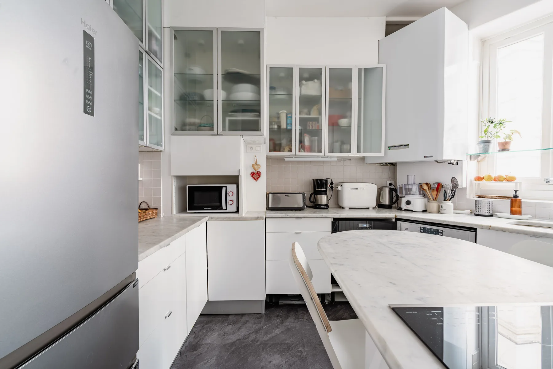 Una cocina luminosa con gabinetes blancos y una amplia isla central.