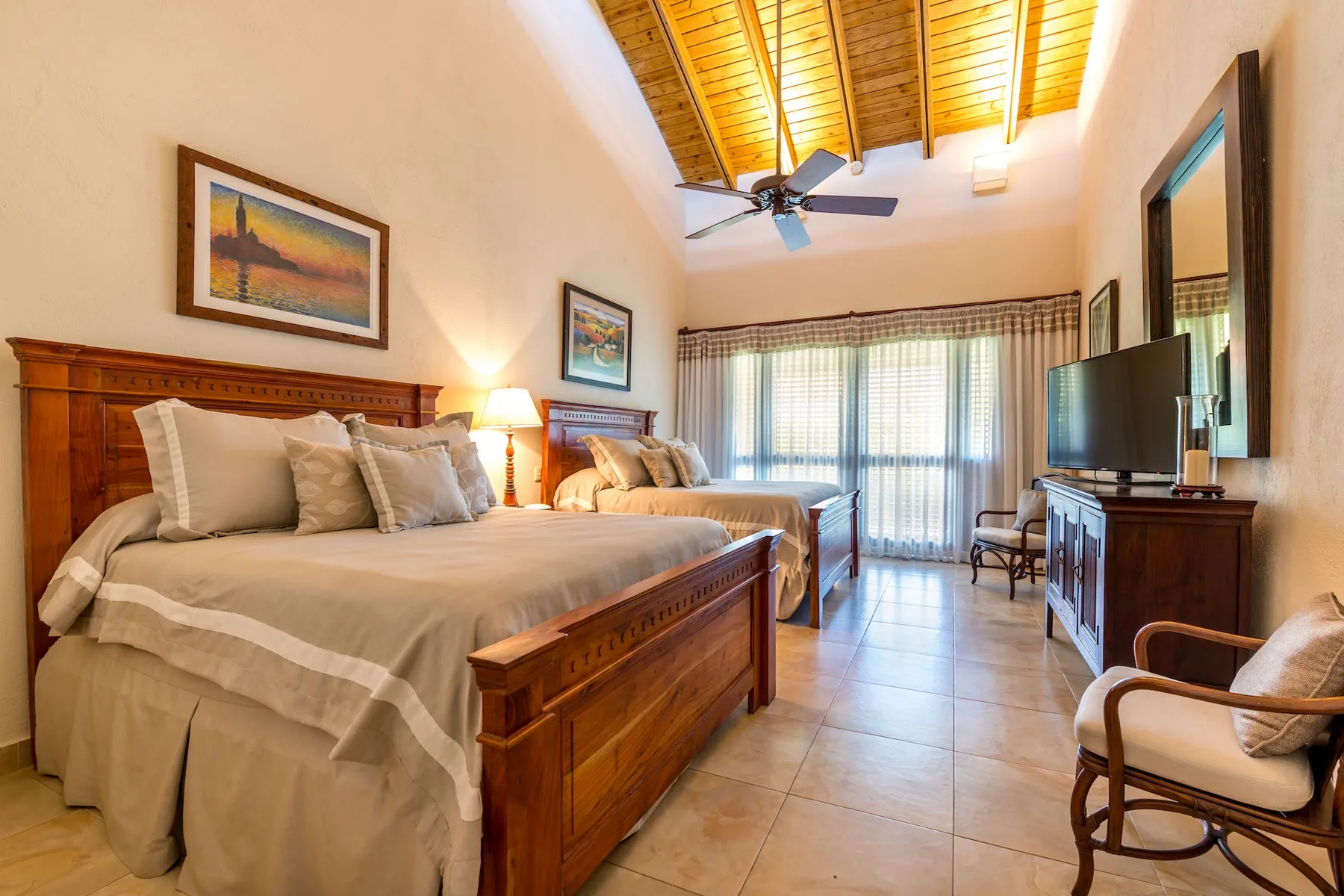 Un dormitorio con una cama grande, muebles de madera y puertas corredizas de vidrio.