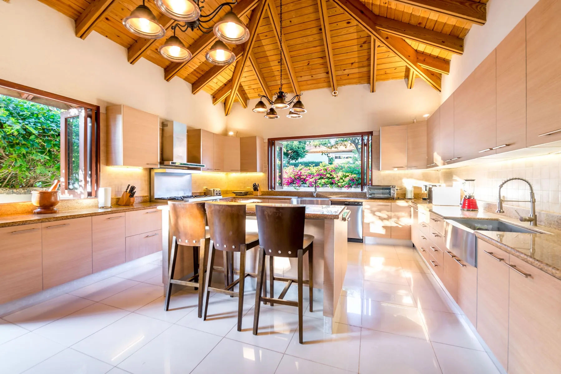 Una cocina luminosa con una isla central y vigas de madera expuestas en el techo.