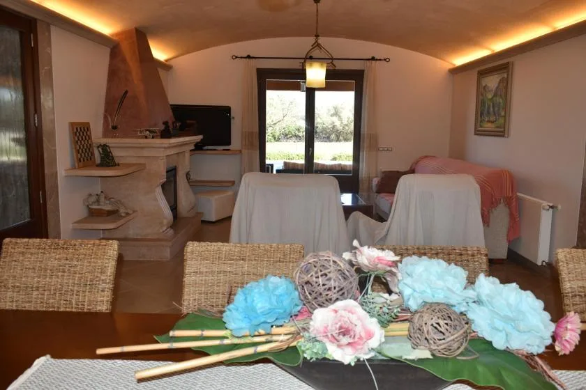 Un comedor con una mesa decorada con flores y asientos junto a una chimenea.