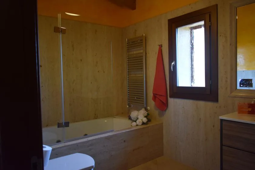 Un baño con bañera, ducha y ventana.