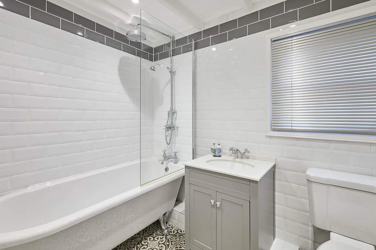A tiled bathroom with a bathtub, shower, and sink.