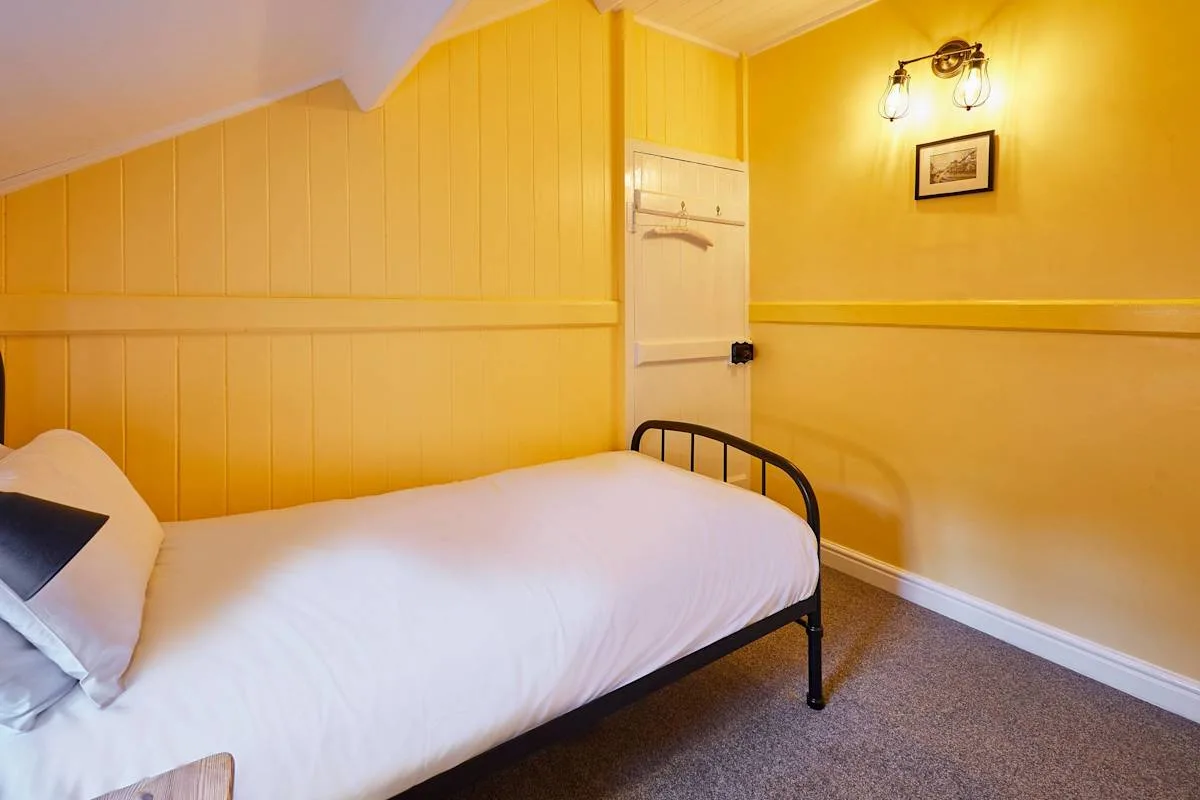 A bedroom with a bed beneath a sloped ceiling.