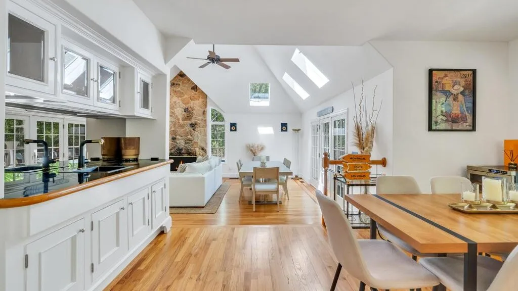 Una luminosa cocina y comedor de concepto abierto con una larga mesa de madera.