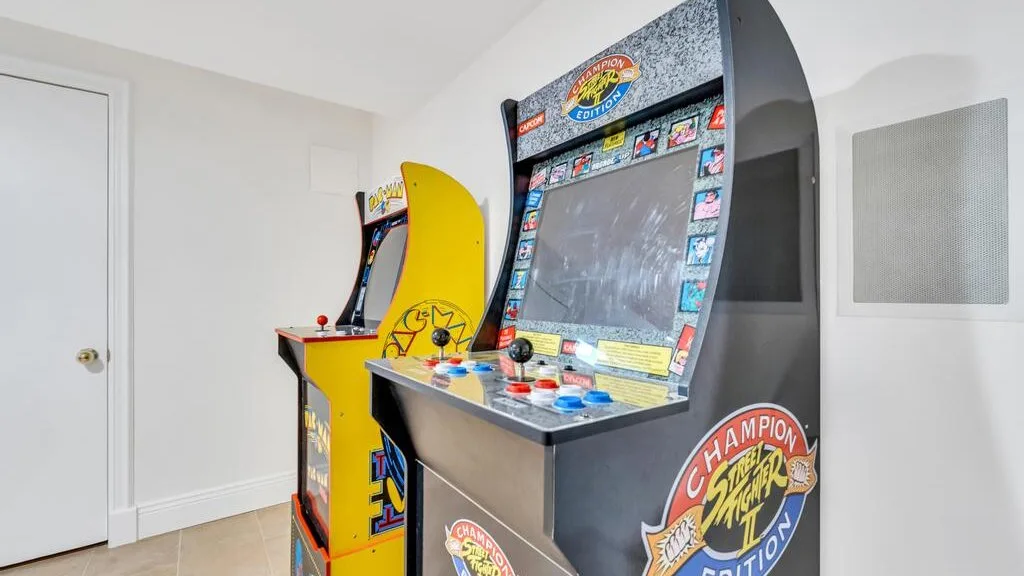 Una zona de juegos interior con dos máquinas recreativas coloridas.