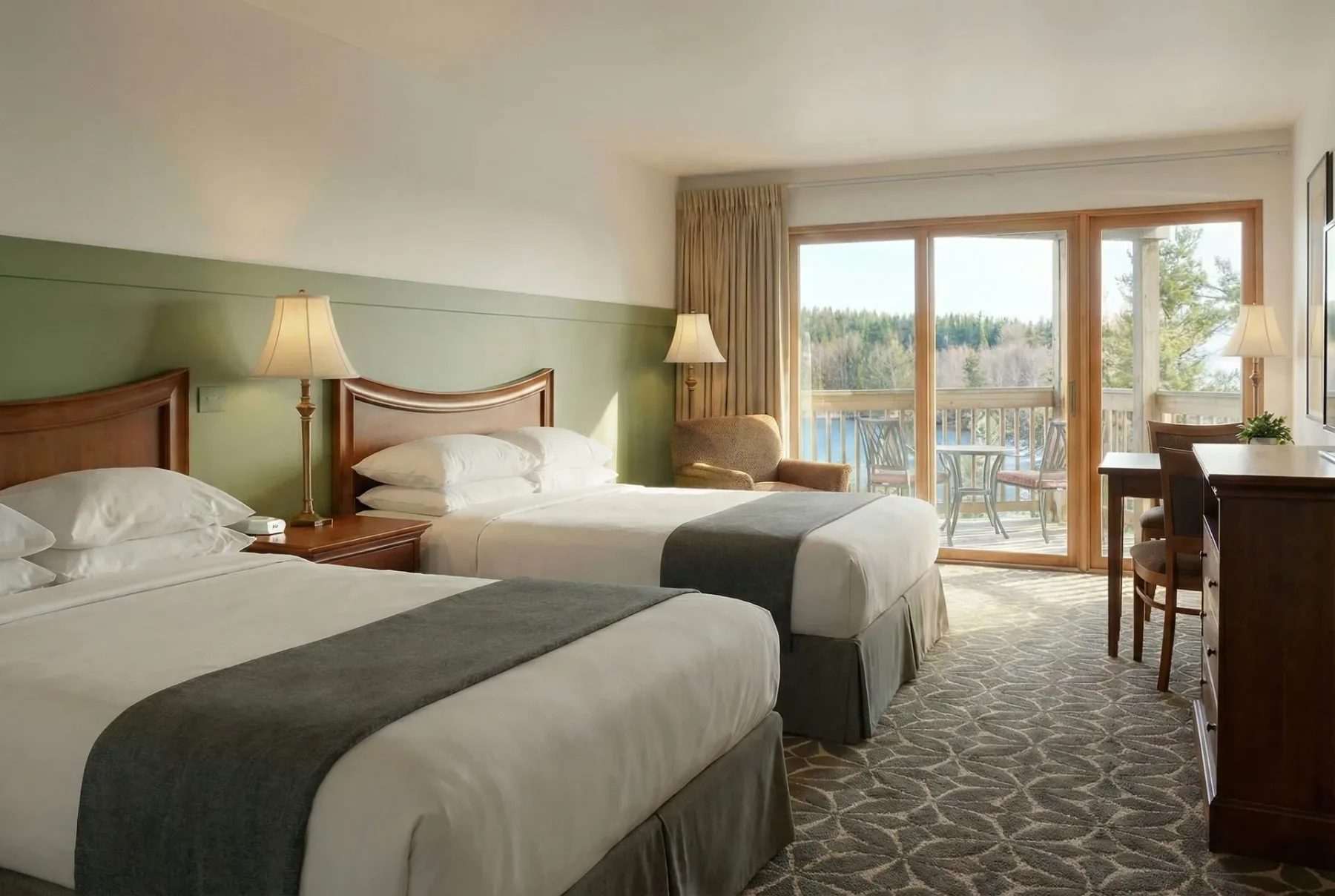 Guest room with two beds and balcony view.