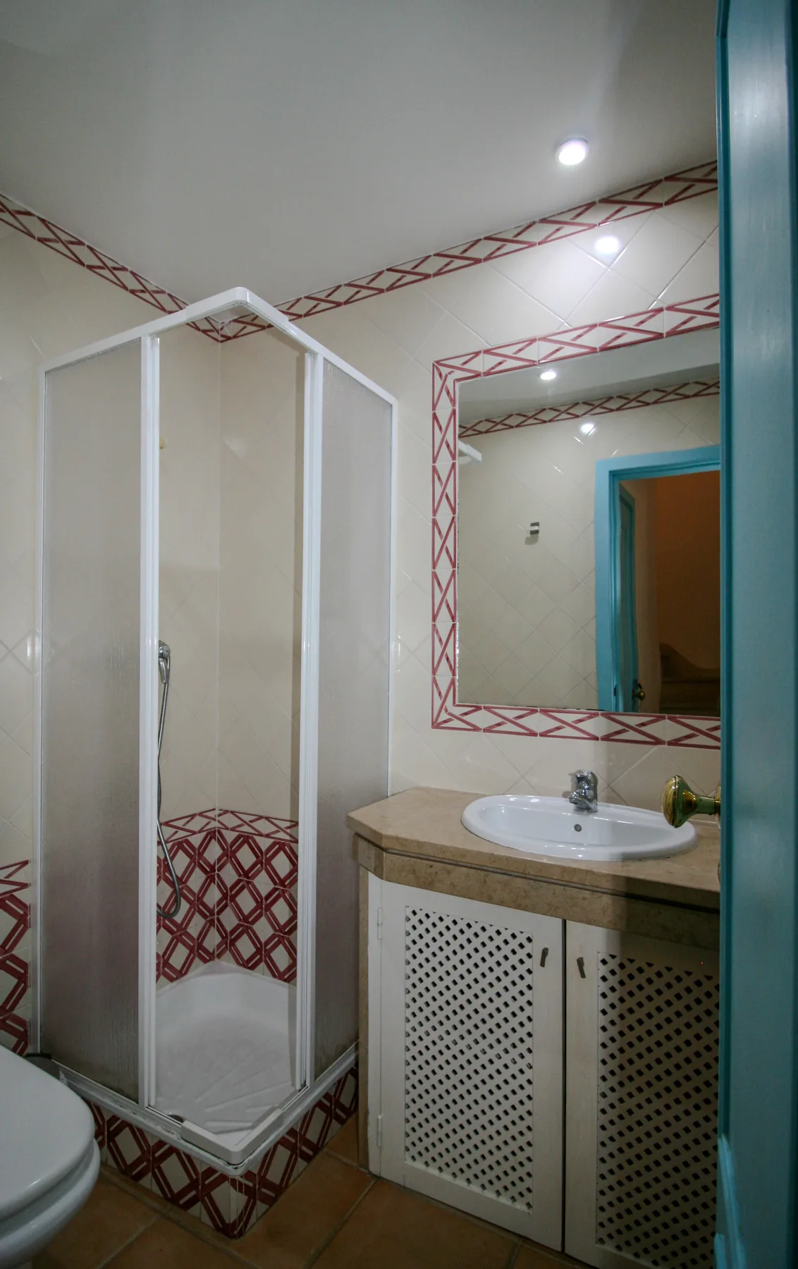 A bathroom with a shower, sink, and wall mirror.