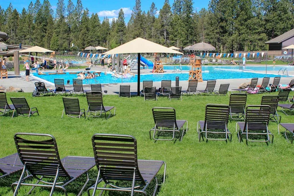 Una piscina al aire libre con tumbonas dispuestas sobre el césped.