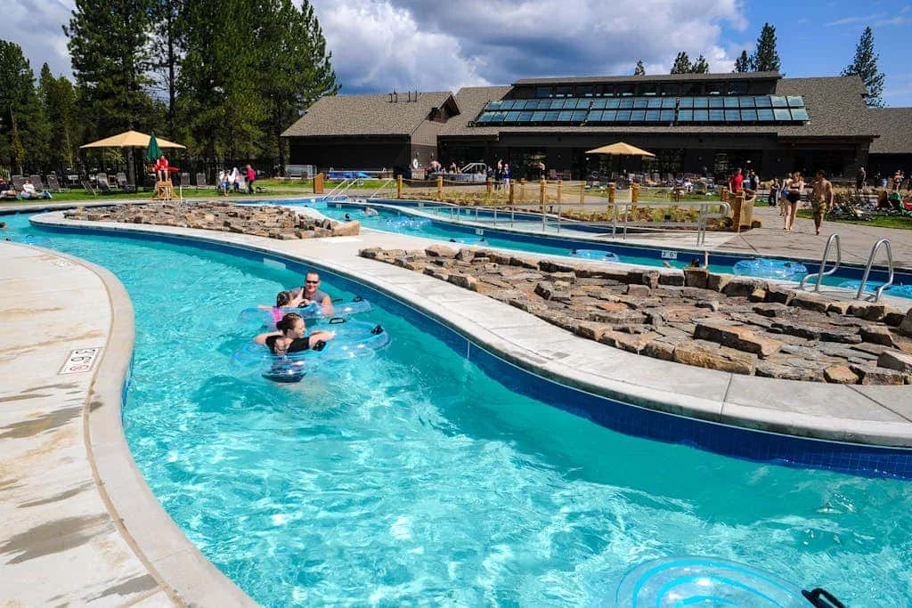 Una piscina al aire libre bordea un margen de piedra junto a un edificio bajo.