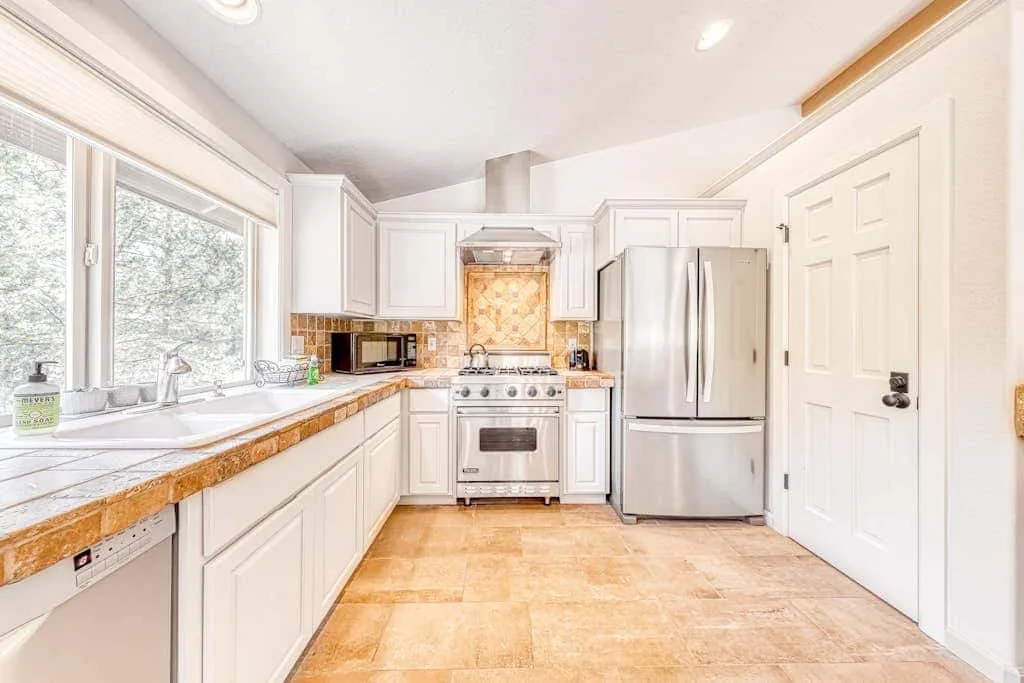 A bright kitchen with white cabinets and stainless-steel appliances.