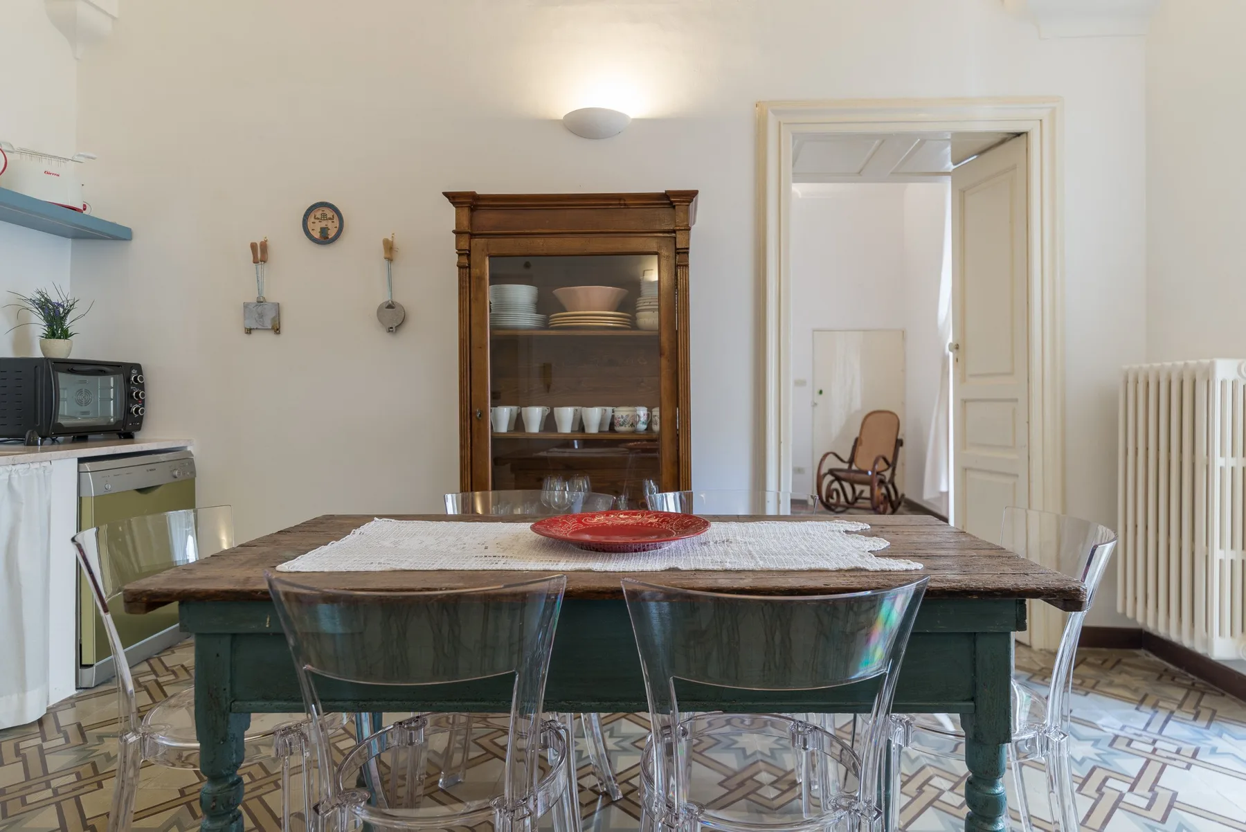 Un comedor con una mesa larga frente a un mueble de madera para vajilla.