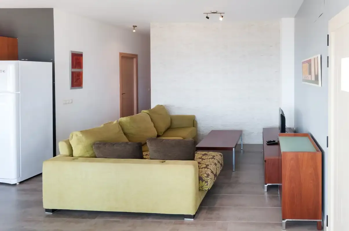Sala de estar con asientos, una mesa de centro y un televisor.