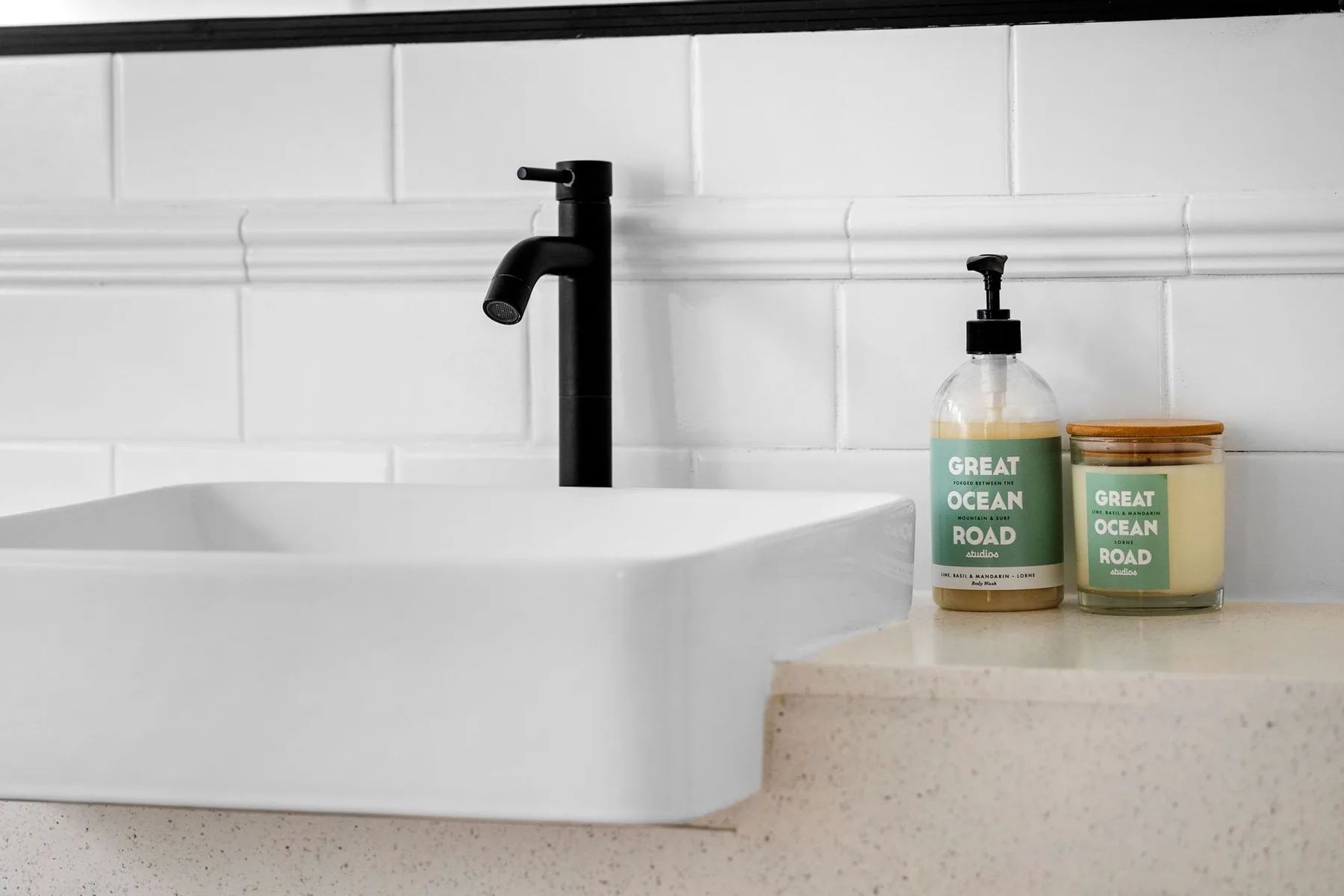 A bathroom sink with a black faucet and toiletries on the counter.
