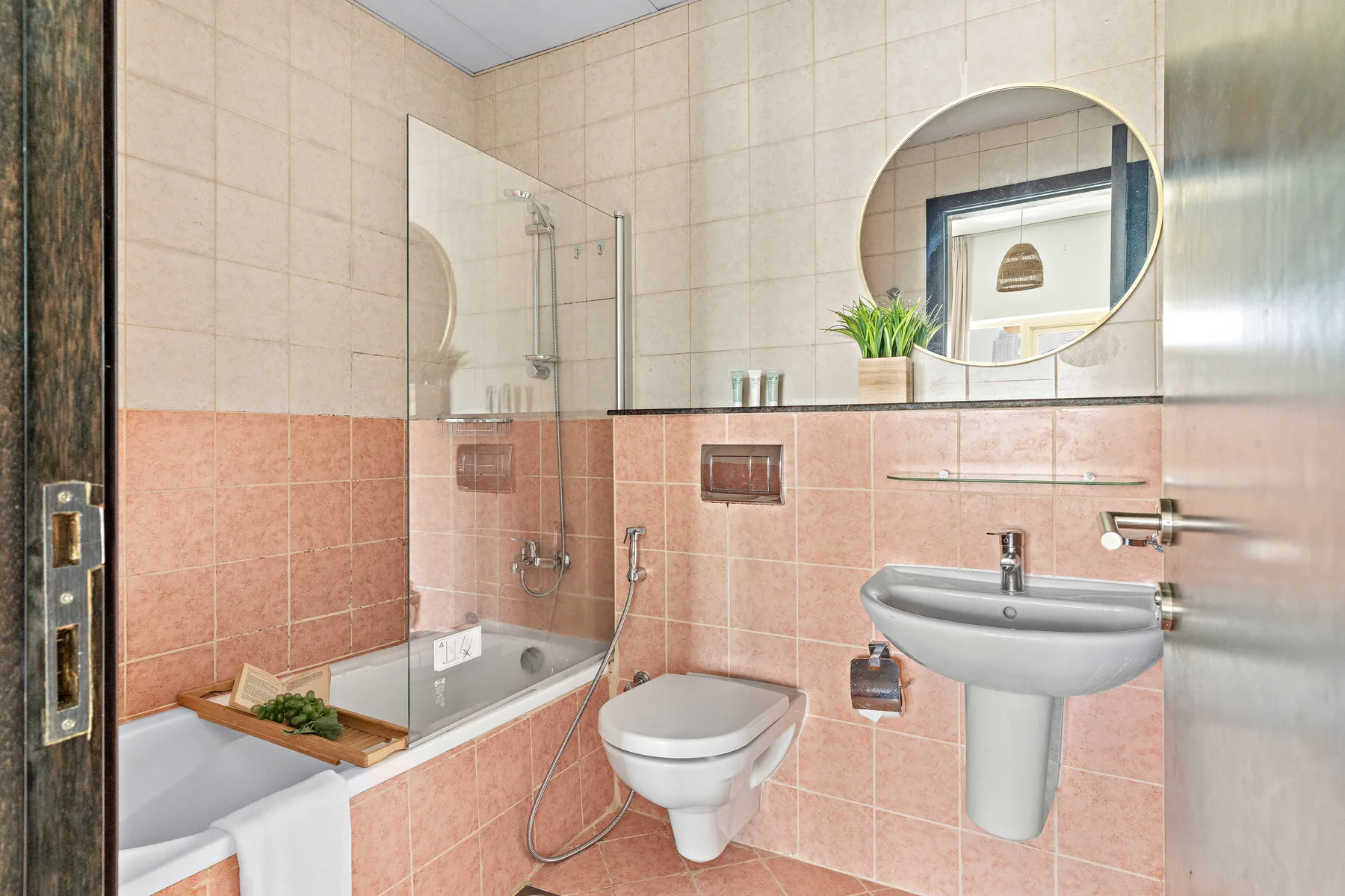 A tiled bathroom with a bathtub, shower, toilet, and sink.