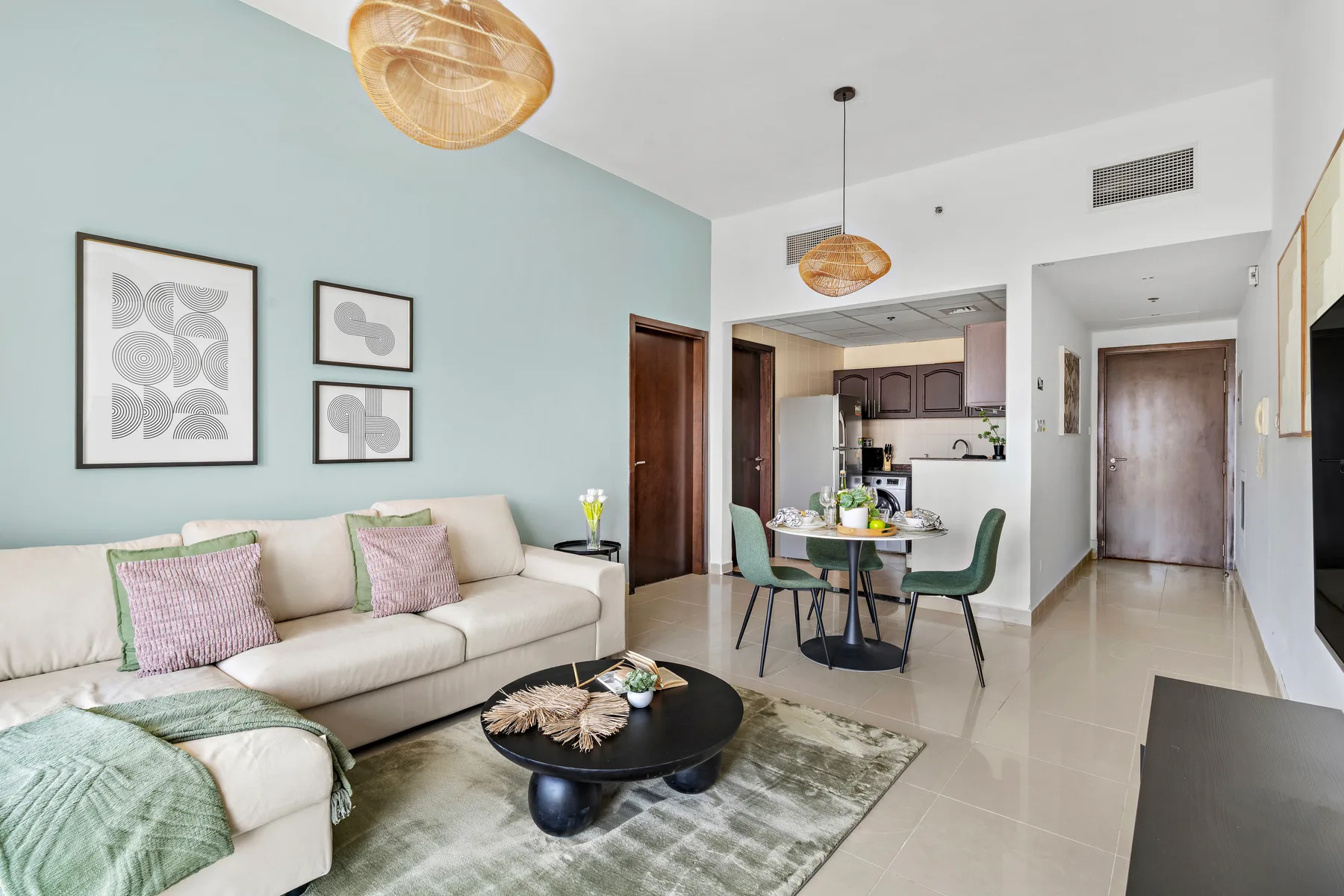 A bright living room opens onto a dining area and compact kitchen.