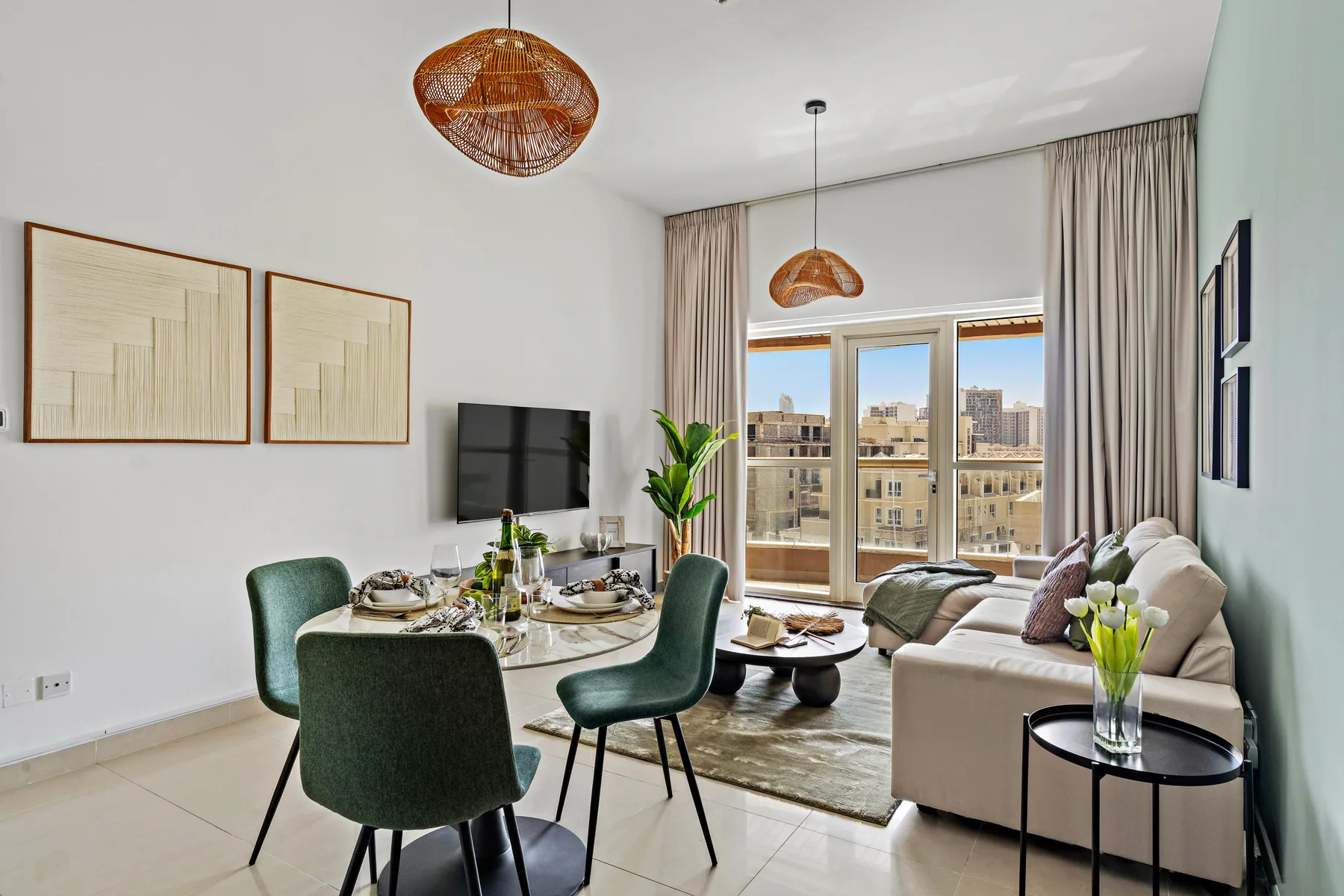 A bright living and dining area opens onto a balcony through large glass doors.