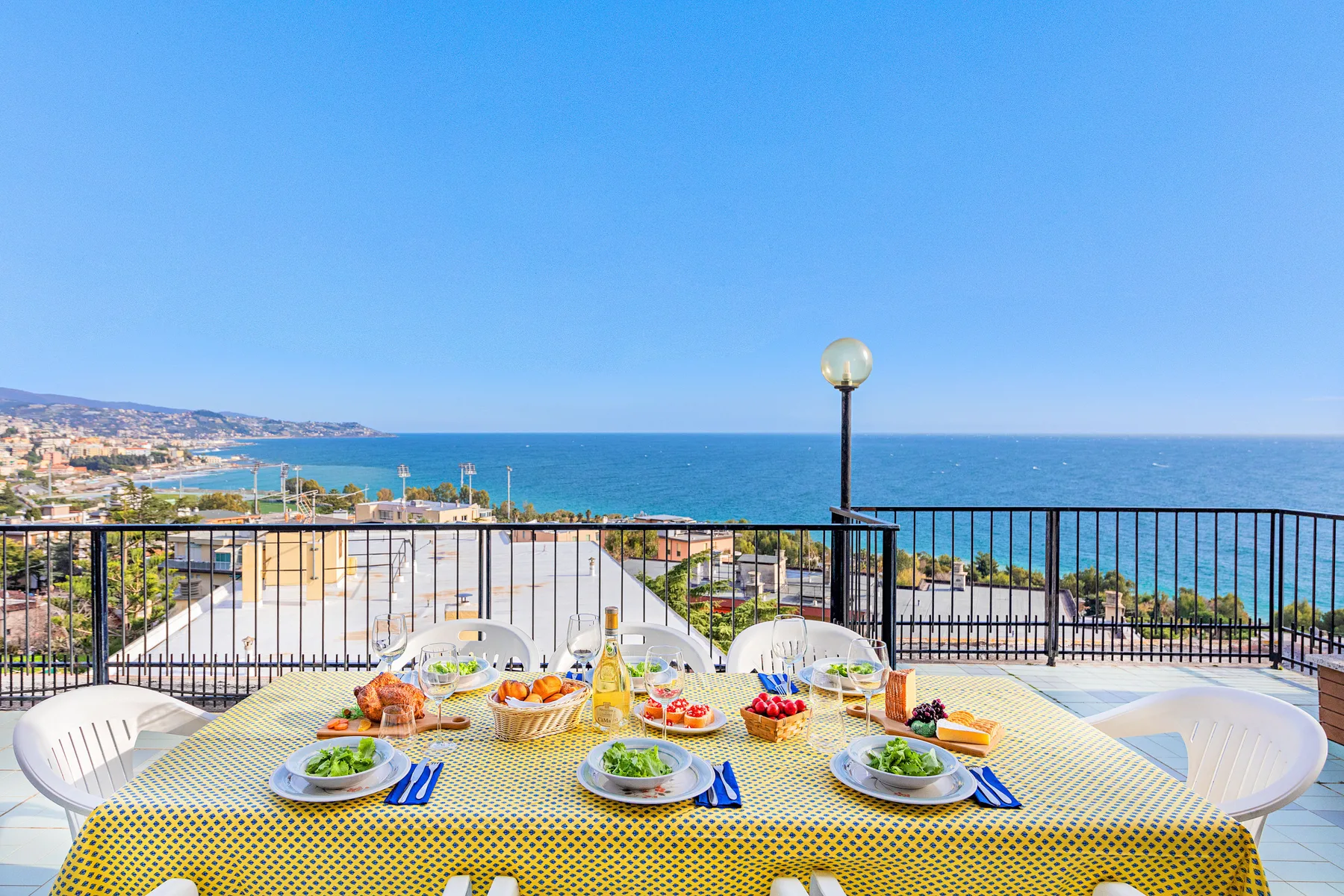 Una terraza junto al mar con una mesa preparada para comer y vistas al agua.