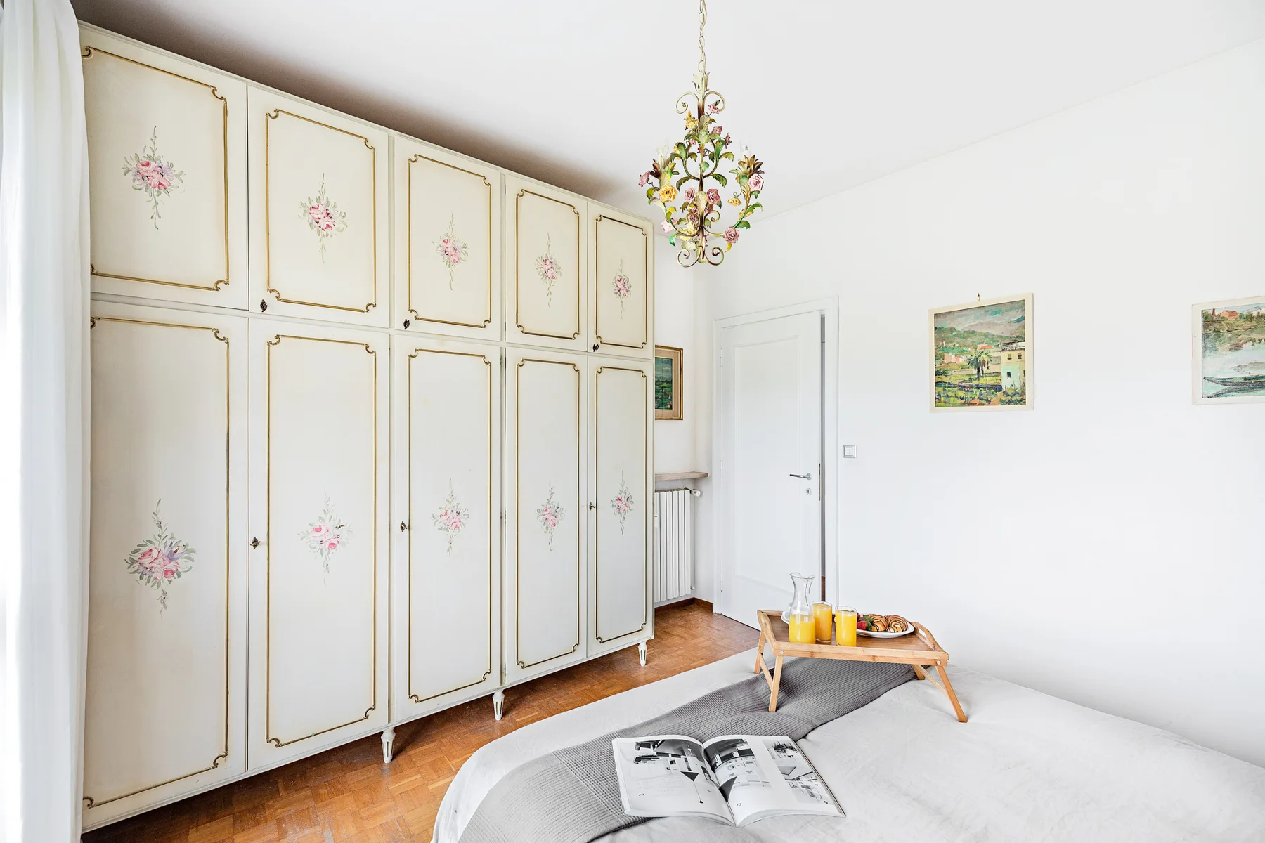 Un dormitorio luminoso con armarios empotrados, una cama y una mesa pequeña.