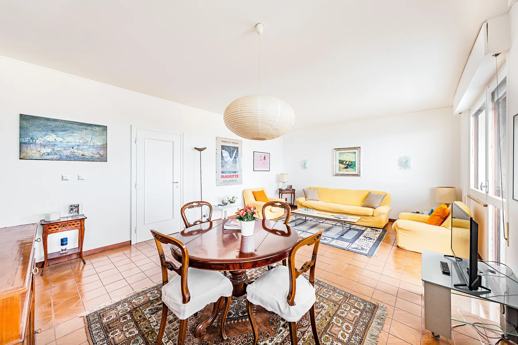 A bright living and dining room with a dining table and seating area.