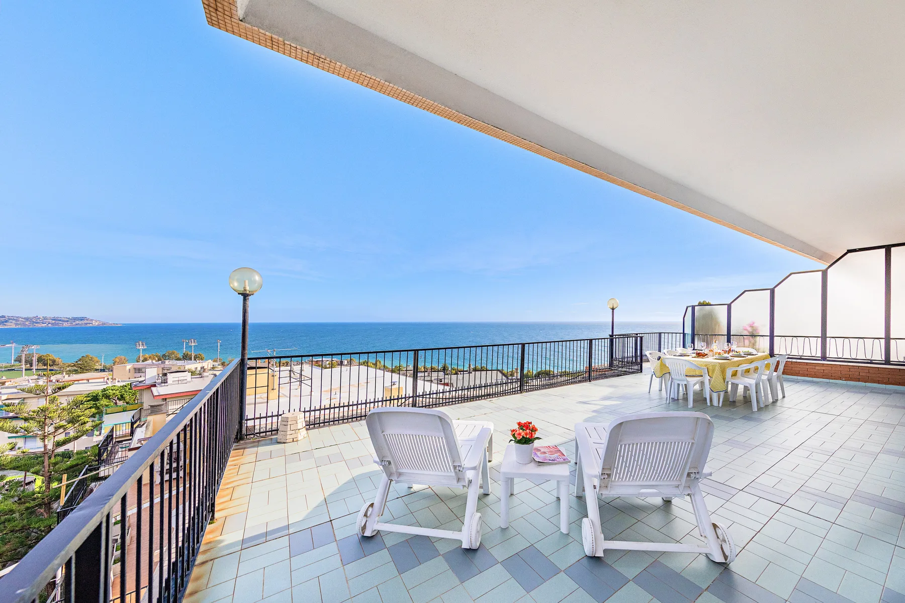 Una terraza junto al mar con asientos al aire libre y vistas al océano.