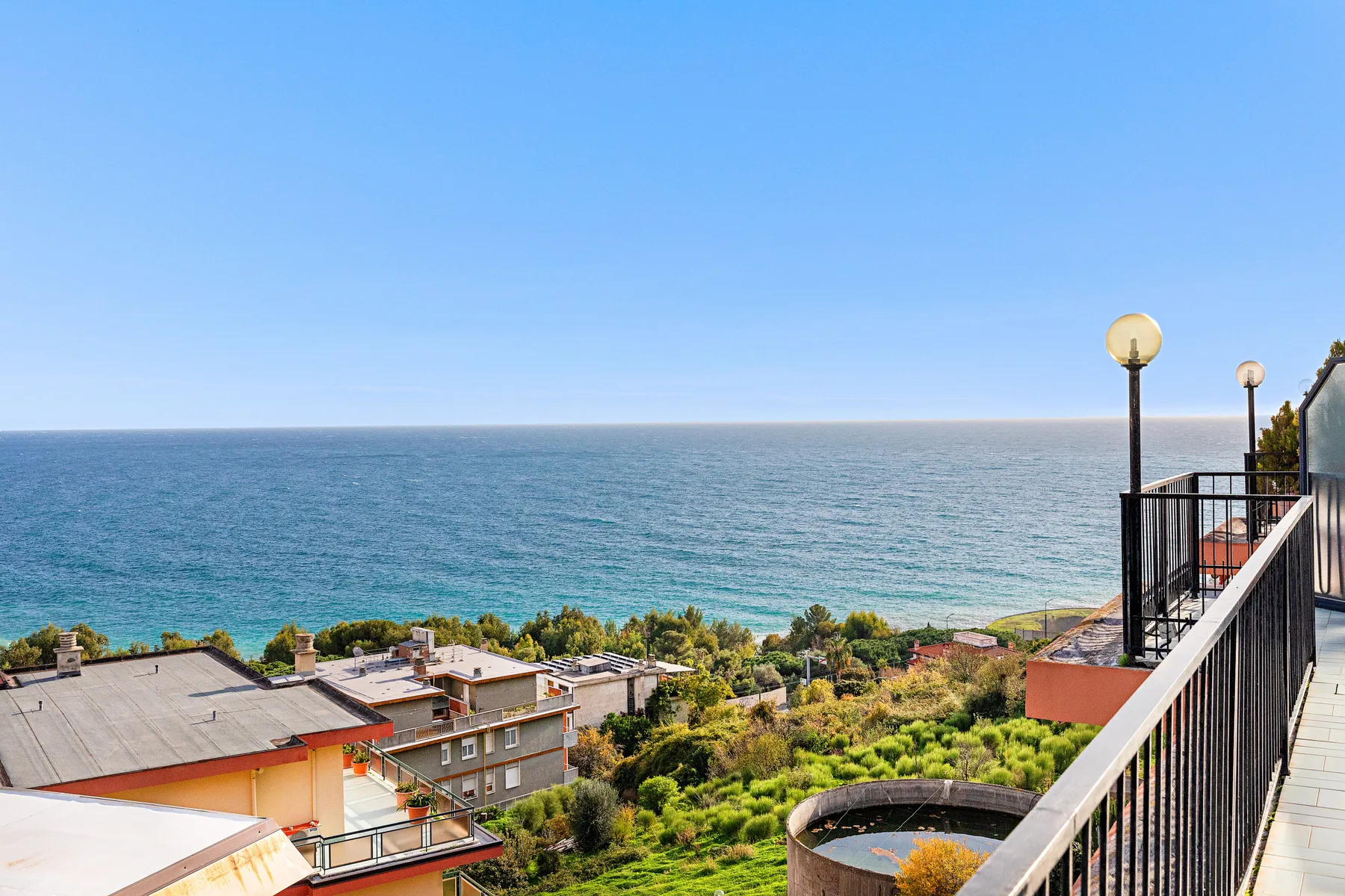 Vista costera desde un balcón hacia el mar y los edificios cercanos.