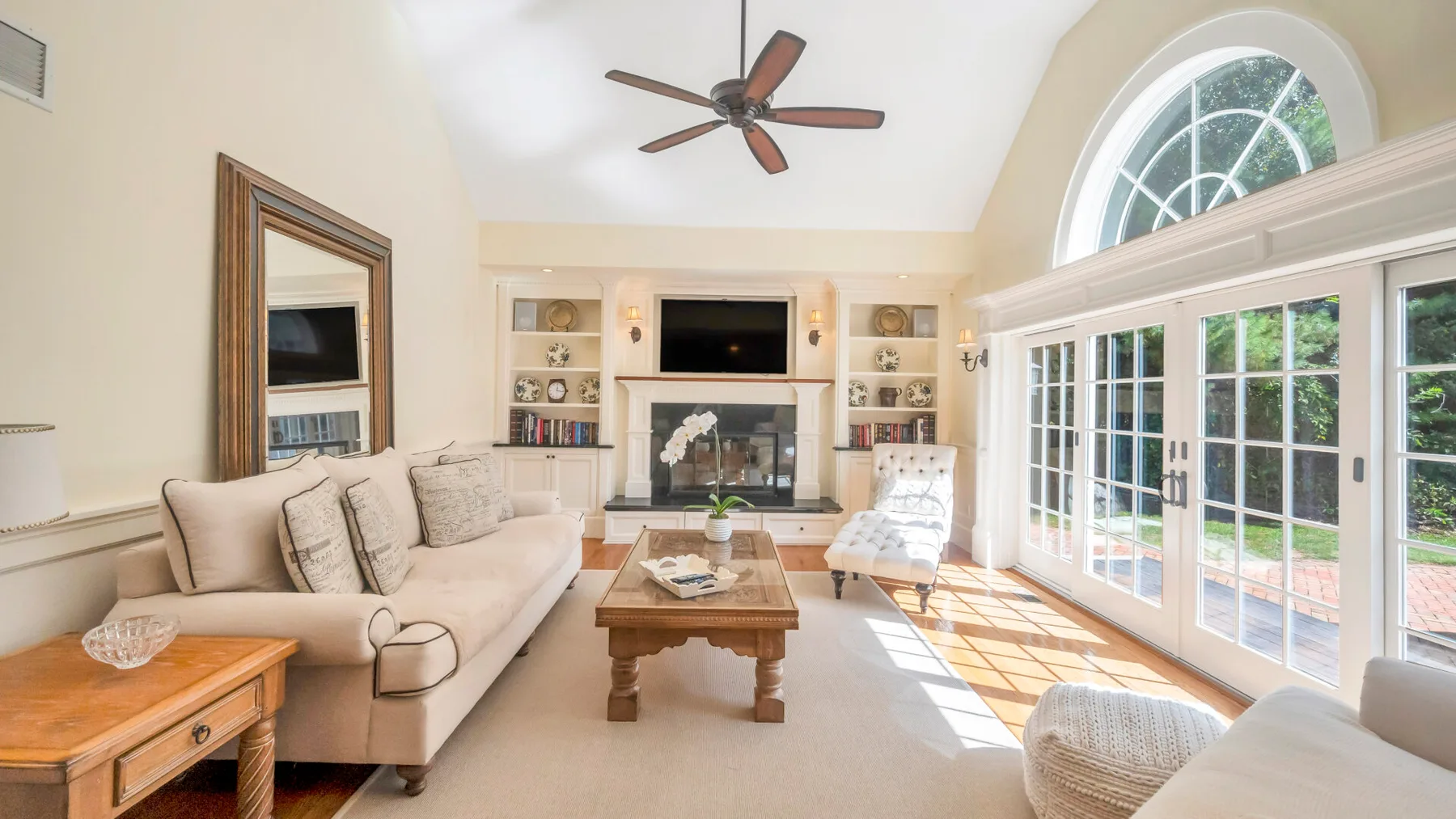 Una sala de estar luminosa con asientos, chimenea y ventanas grandes.