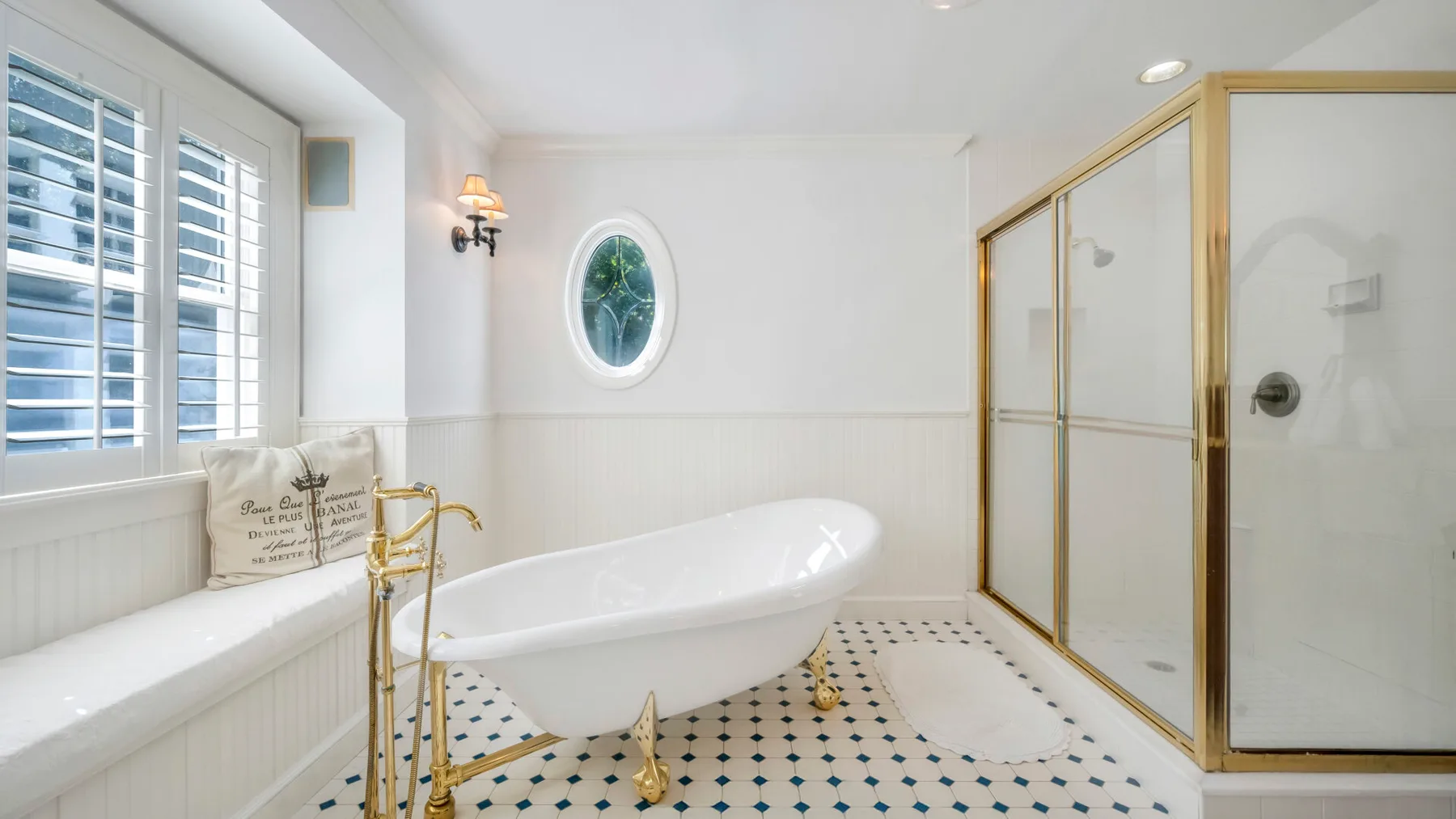 Un baño luminoso con bañera exenta y ducha de vidrio.