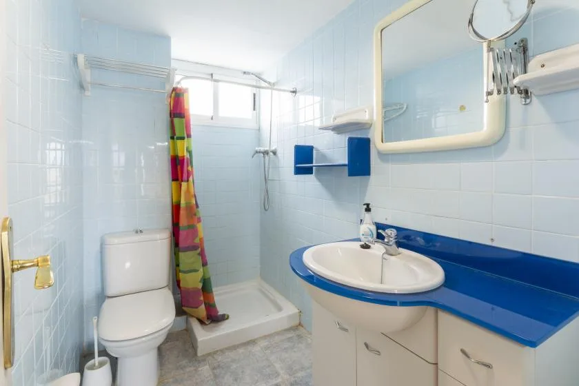 A tiled bathroom with a shower, toilet, and sink.