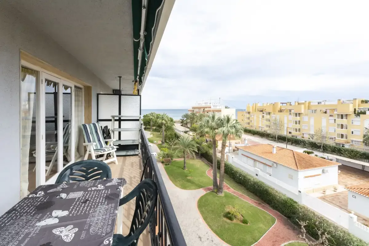 A balcony overlooks landscaped grounds and nearby apartment buildings.