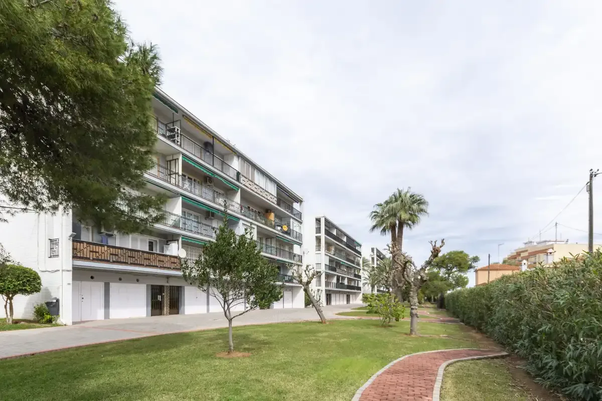 Apartment buildings overlook a landscaped lawn and curved brick path.