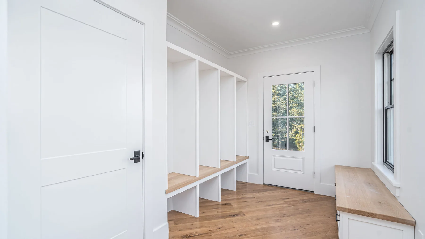 A bright room with built-in open shelving and a white door.