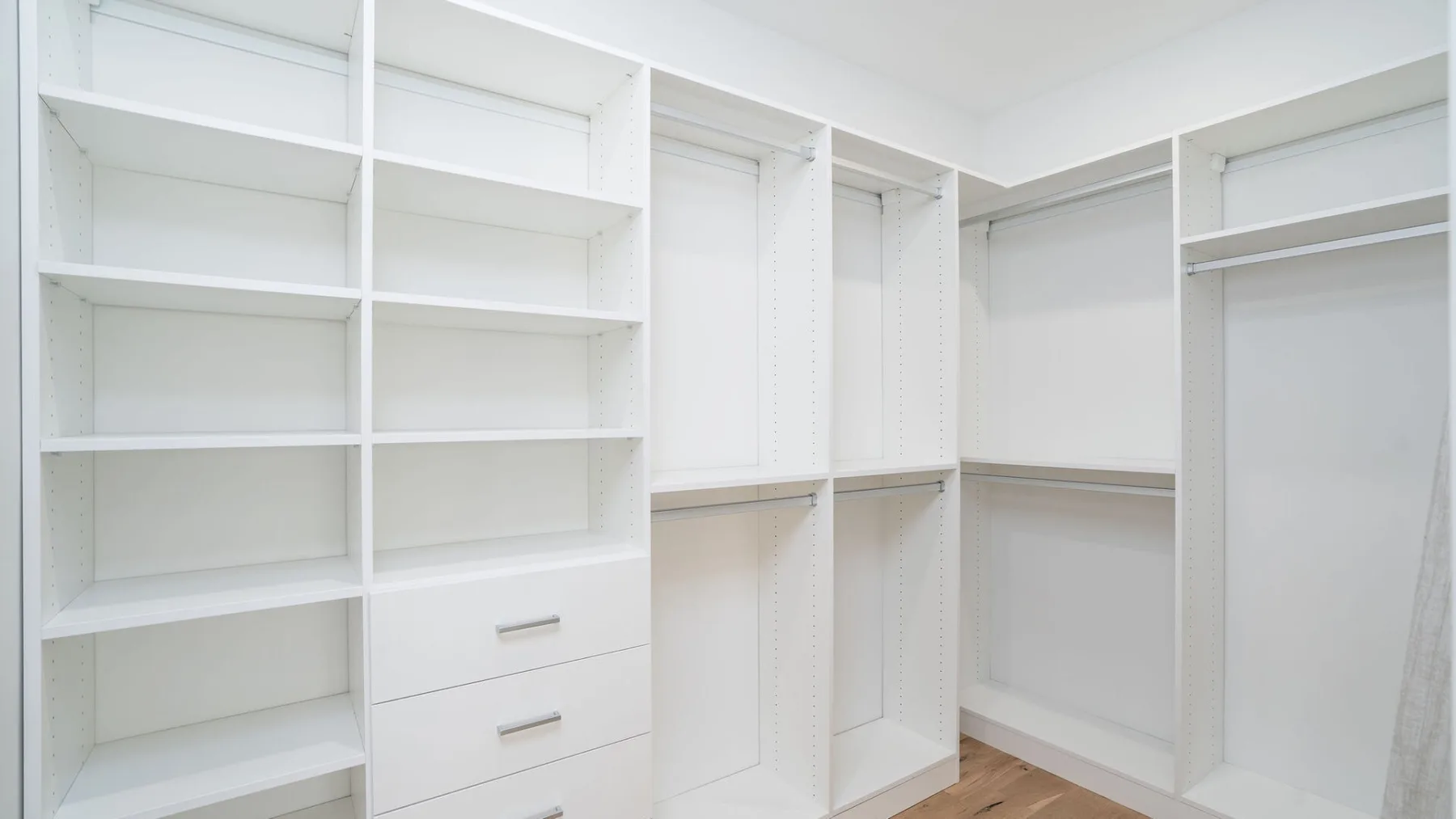 A bright walk-in closet with open shelving and hanging space.