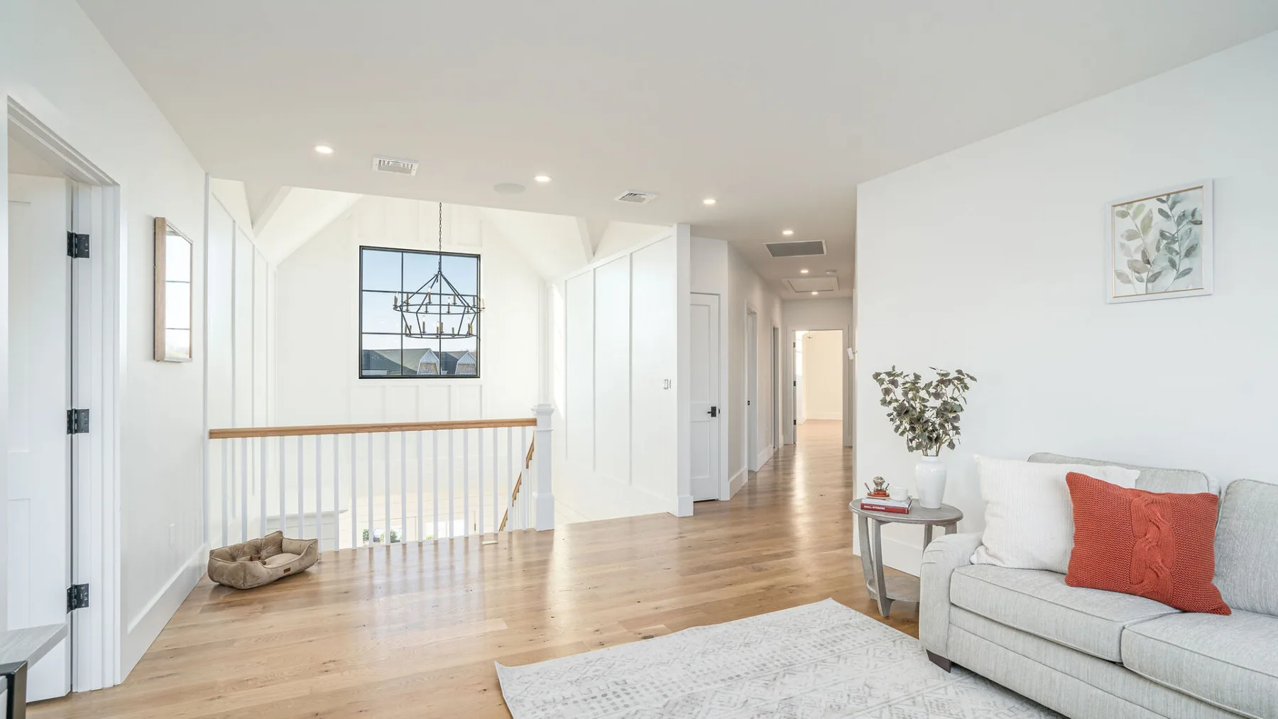 A bright living room with a sofa and a hallway beyond.