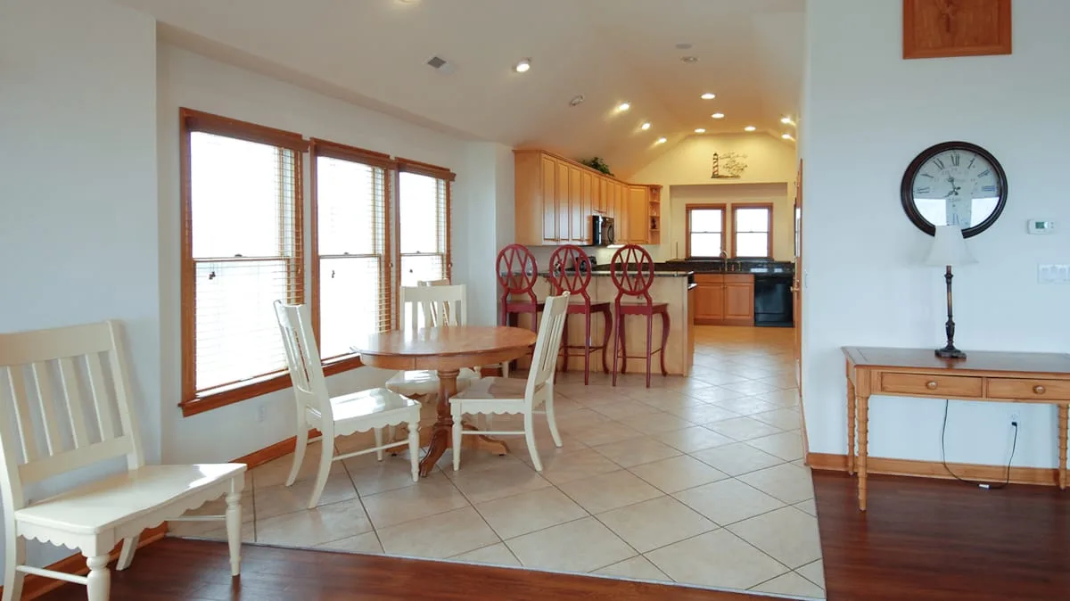 Comedor con una mesa de madera y sillas junto a una cocina.