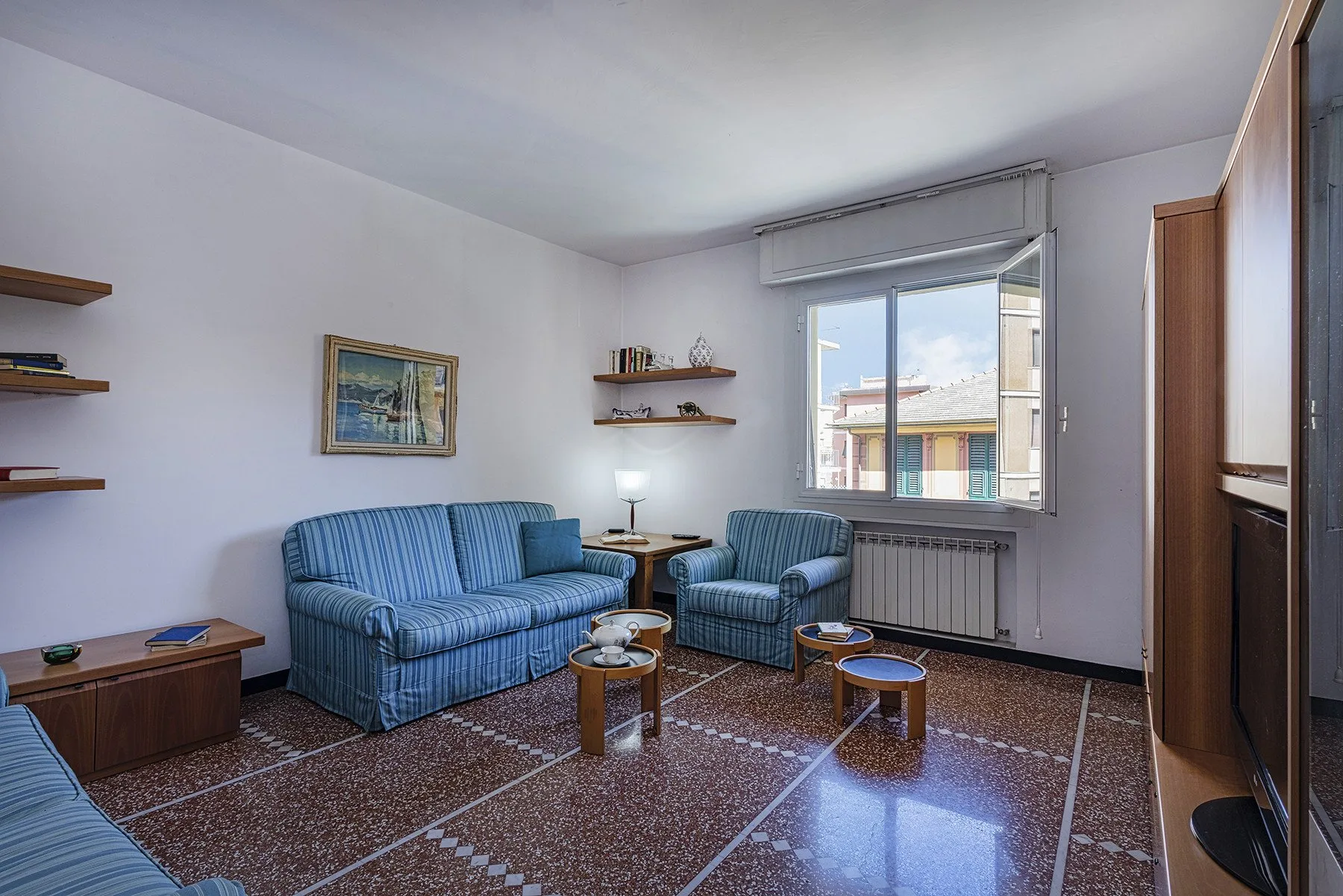 A living room with blue seating arranged around a small coffee table.