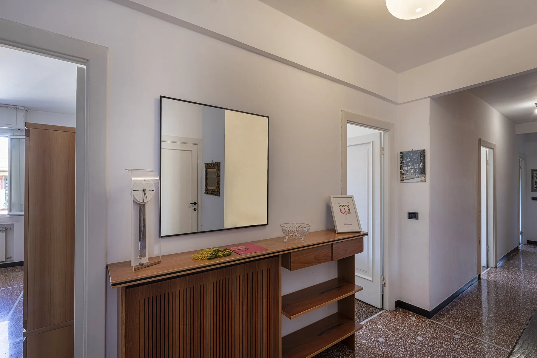 An entry hall with a wooden console table and a large wall mirror.