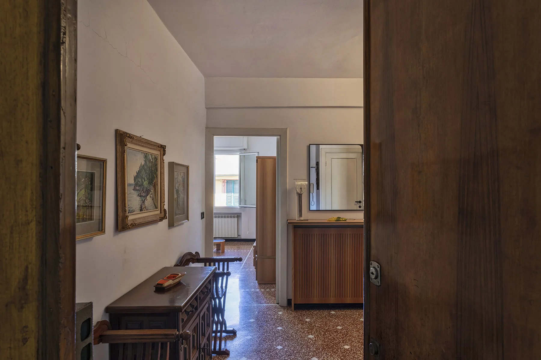 Interior hallway with framed artwork and a wooden console table.
