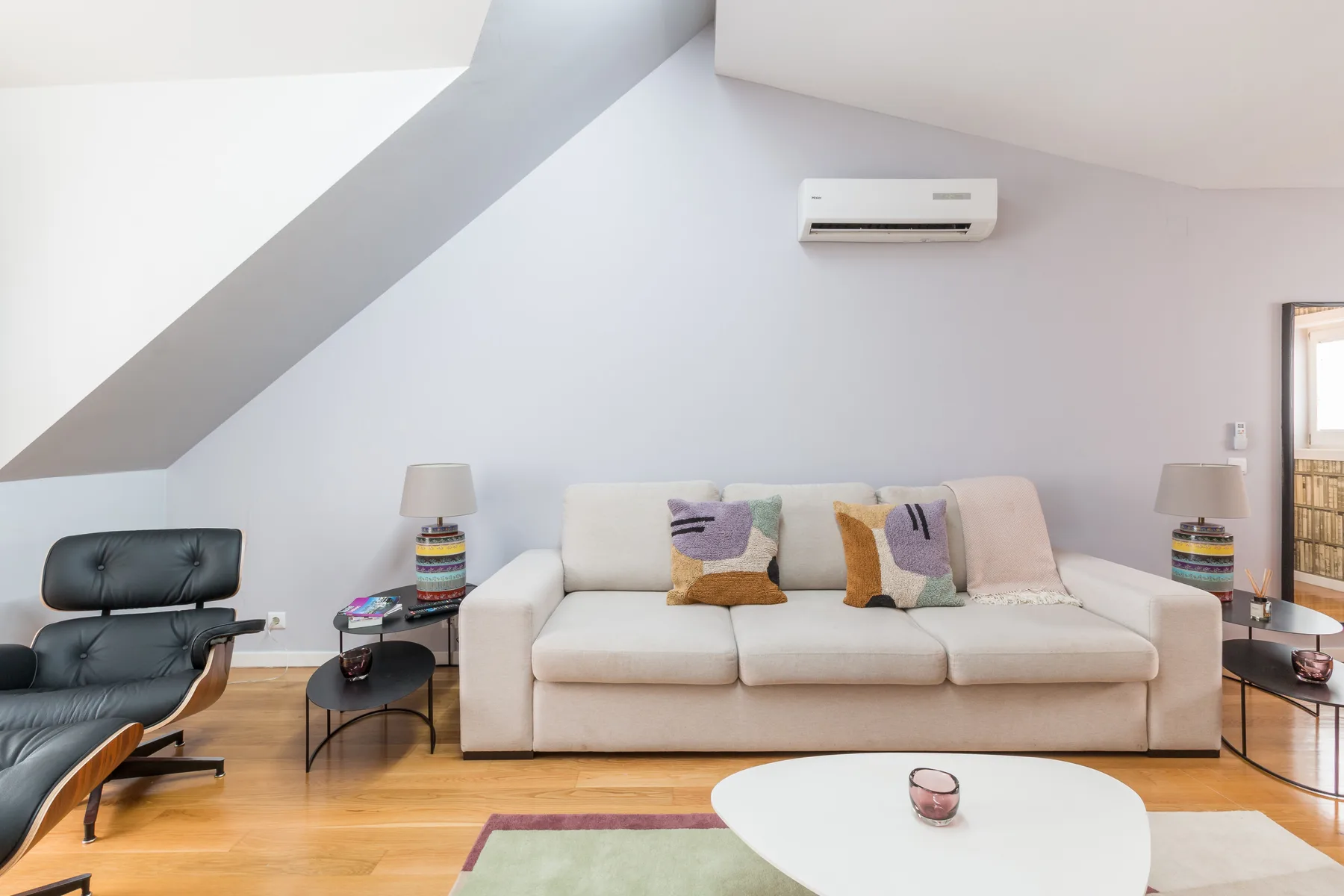 Una sala luminosa con un sofá, un sillón y una mesa baja.