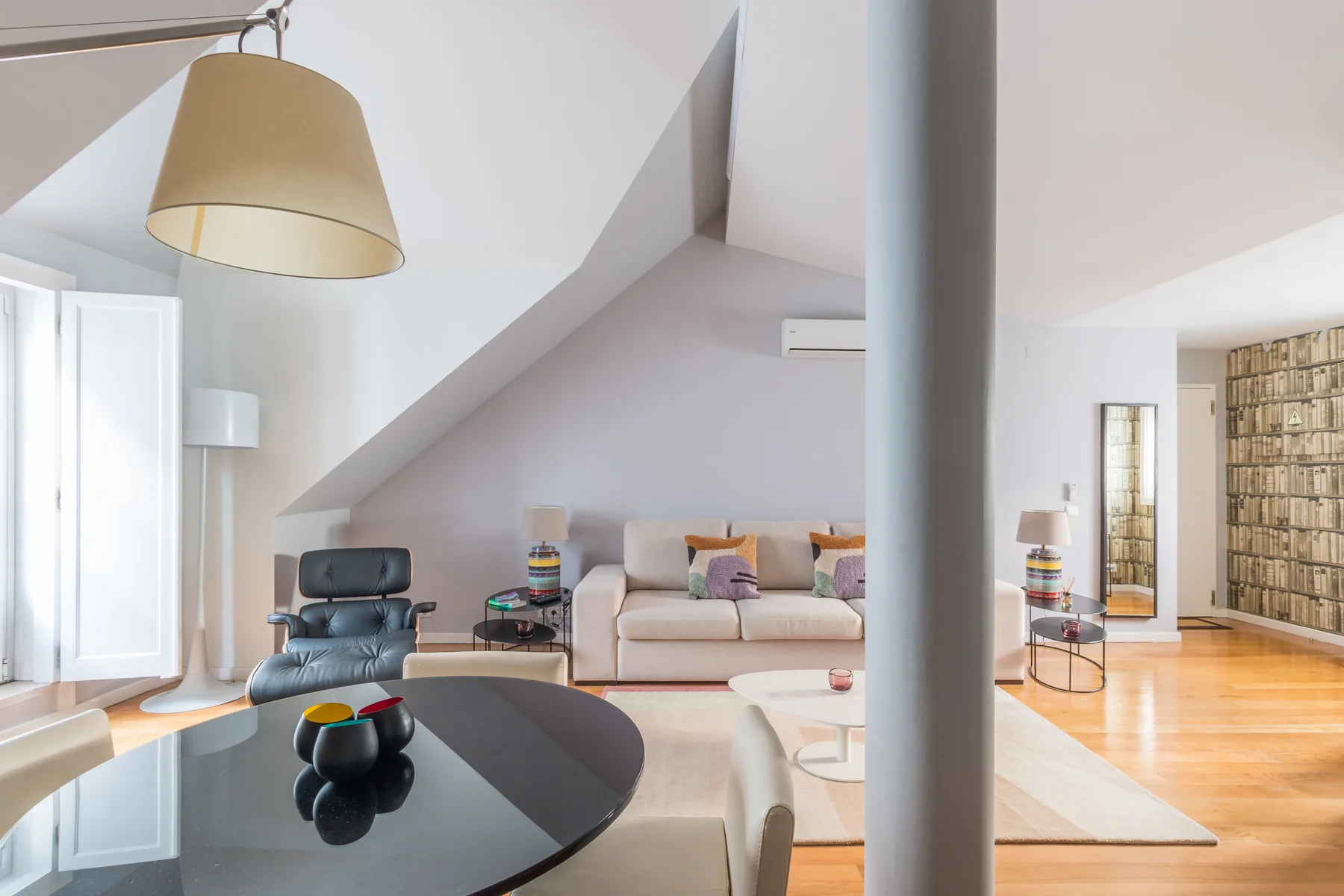 Una sala de estar luminosa con asientos, una mesa de centro y estanterías.