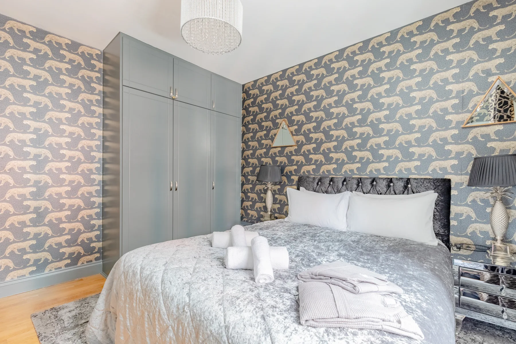 Dormitorio con una cama y un armario alto de color gris.