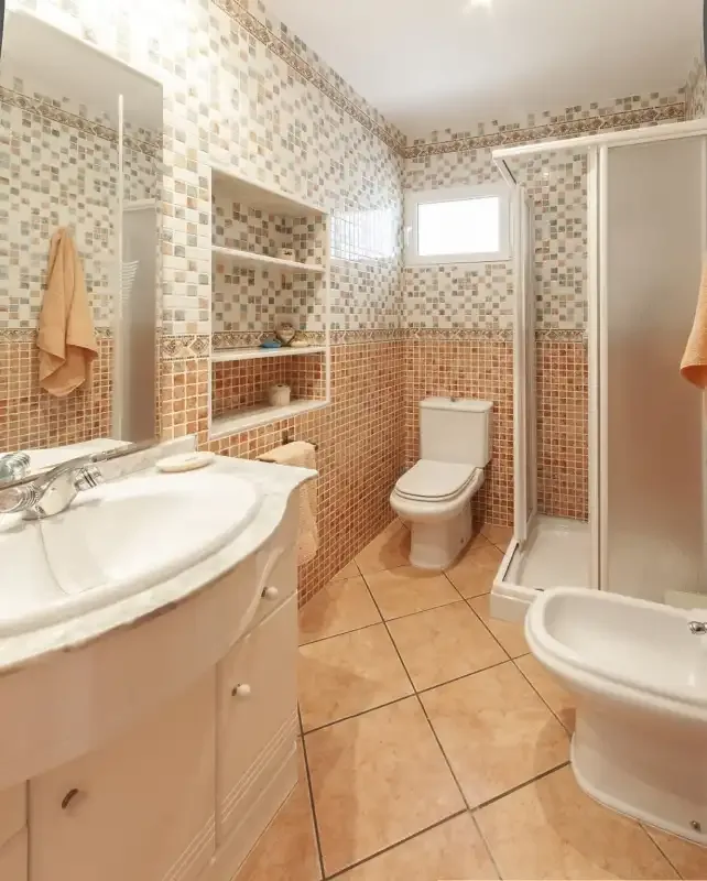 A tiled bathroom with a sink, toilet, and shower.