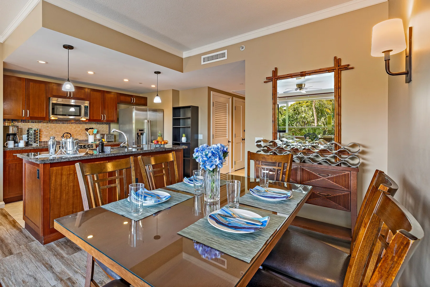Comedor con la mesa puesta junto a una cocina abierta.