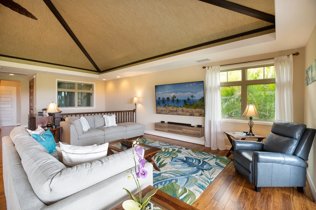 A living room with seating arranged around a television and a large patterned rug.