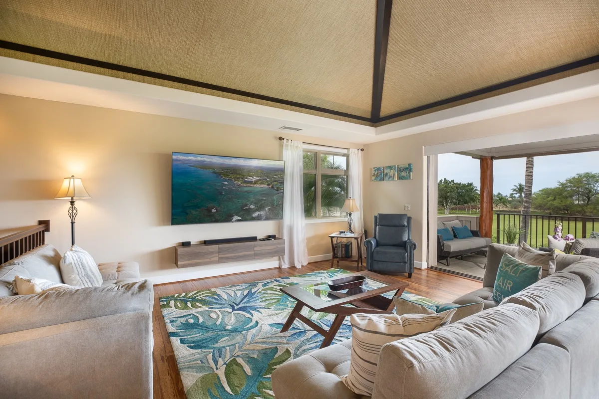 A bright living room with seating around a coffee table and a large window.