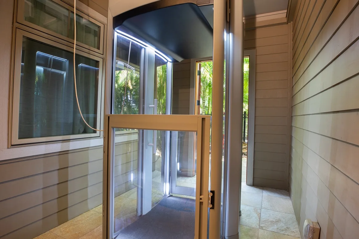 A narrow enclosed entryway with glass doors and windows.