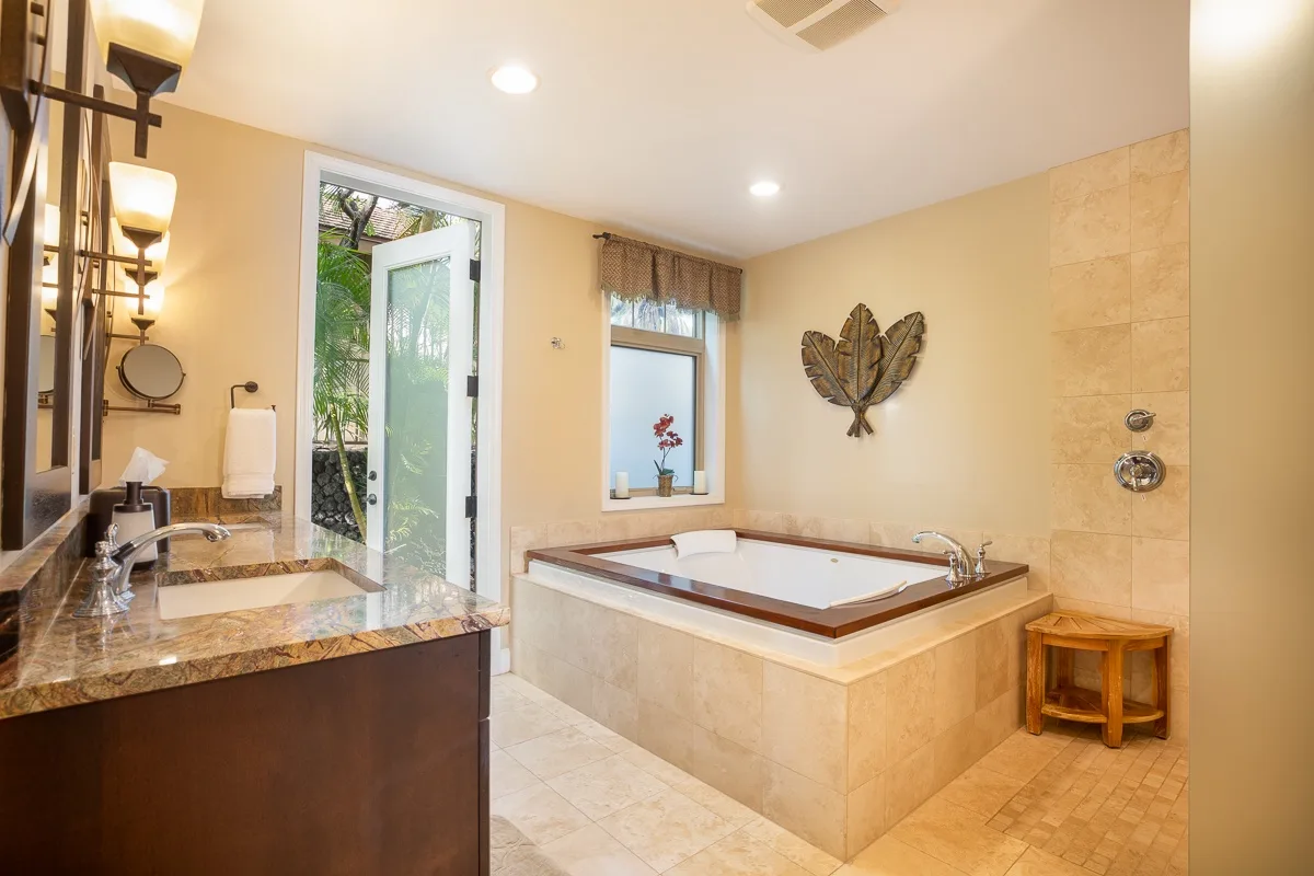 A bright bathroom with a built-in soaking tub and vanity.