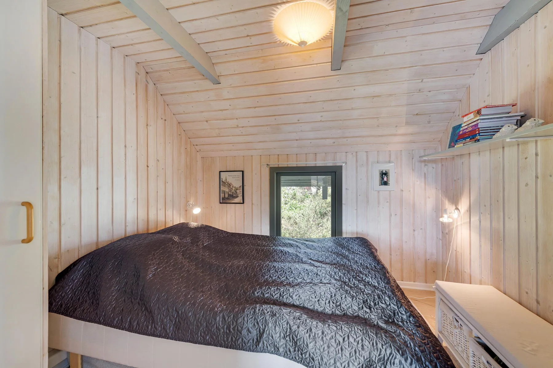 Un dormitorio con una cama grande y una ventana con vistas a la vegetación.