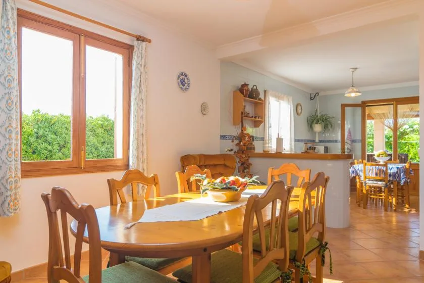 Un comedor con una larga mesa de madera junto a una ventana.